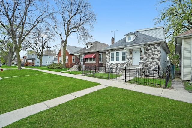 view of front of house featuring entry steps, a fenced front yard, a front lawn, and stone siding