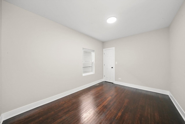 empty room with baseboards and dark wood-style flooring