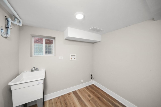 washroom with laundry area, visible vents, baseboards, light wood-style flooring, and washer hookup