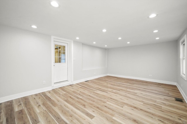 basement with visible vents, recessed lighting, light wood finished floors, and baseboards