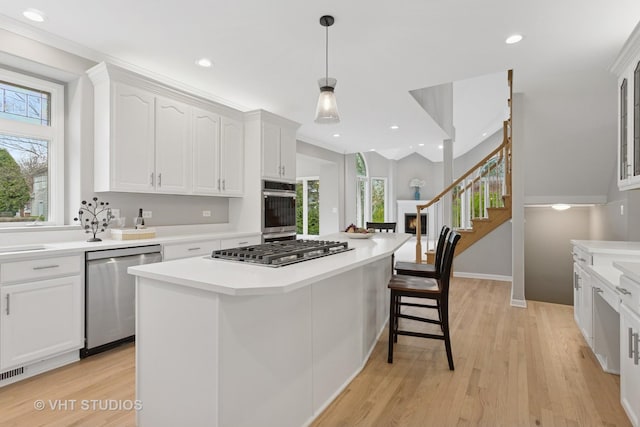 2407 Shaker Ct, Naperville, IL 60564 - kitchen with white cabinets, light countertops, a healthy amount of sunlight, and stainless steel appliances