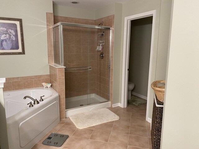 bathroom featuring a bath, tile patterned floors, toilet, and a stall shower