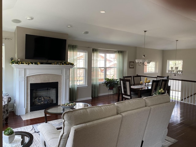 living room featuring a fireplace, wood finished floors, an inviting chandelier, and recessed lighting