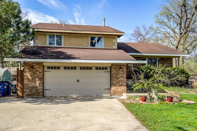 view of front of home with an attached garage, concrete driveway, and brick siding
