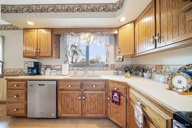 kitchen featuring range with electric cooktop, stainless steel dishwasher, brown cabinets, a sink, and light countertops