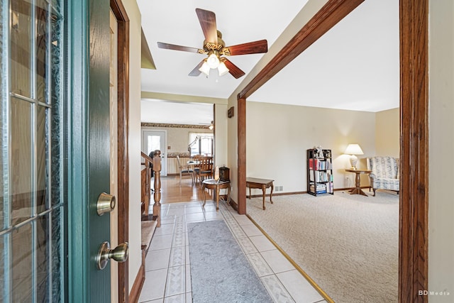 entryway with ceiling fan, light colored carpet, baseboards, light tile patterned floors, and visible vents