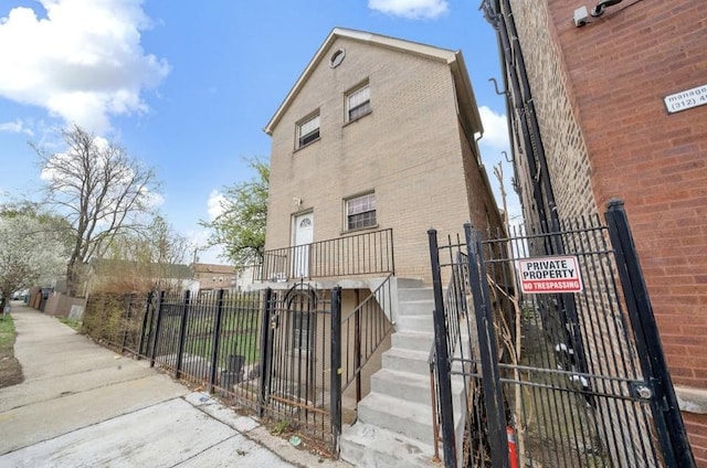 2629 W Luther St, Chicago, IL 60608 - view of side of home featuring brick siding, stairs, a fenced front yard, and a gate