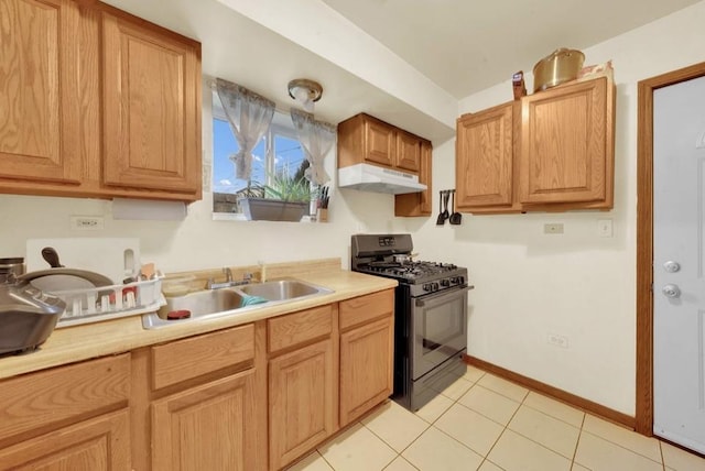 2629 W Luther St, Chicago, IL 60608 - kitchen with a sink, gas stove, light countertops, under cabinet range hood, and light tile patterned floors
