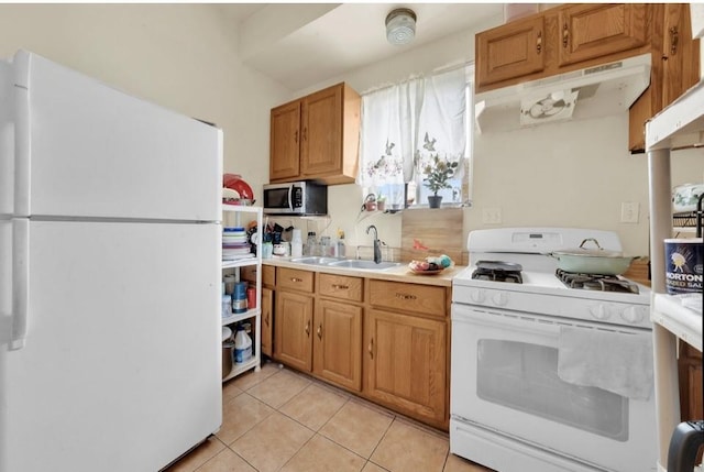 2629 W Luther St, Chicago, IL 60608 - kitchen featuring under cabinet range hood, light countertops, a sink, light tile patterned flooring, and white appliances