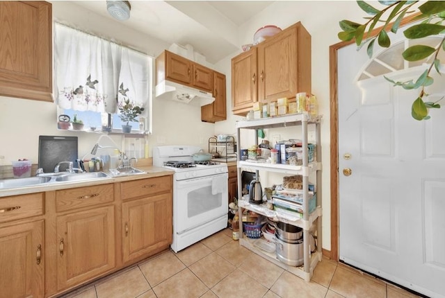 2629 W Luther St, Chicago, IL 60608 - kitchen with under cabinet range hood, light countertops, a sink, white gas stove, and light tile patterned flooring