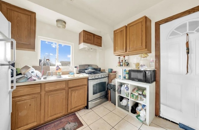 2629 W Luther St, Chicago, IL 60608 - kitchen featuring stainless steel gas stove, light countertops, a sink, freestanding refrigerator, and black microwave