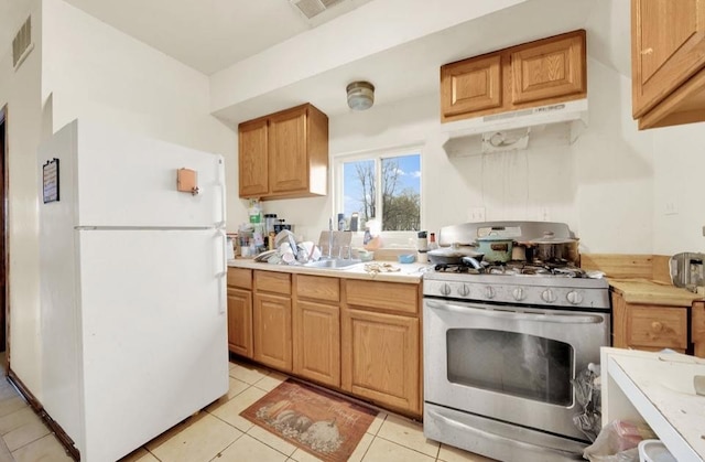 2629 W Luther St, Chicago, IL 60608 - kitchen featuring light countertops, stainless steel range with gas stovetop, visible vents, a sink, and freestanding refrigerator