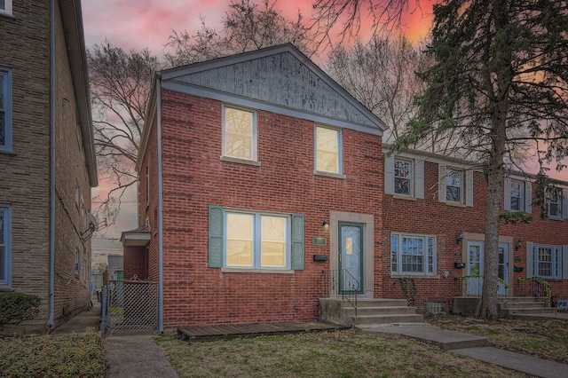 multi unit property featuring brick siding and a gate
