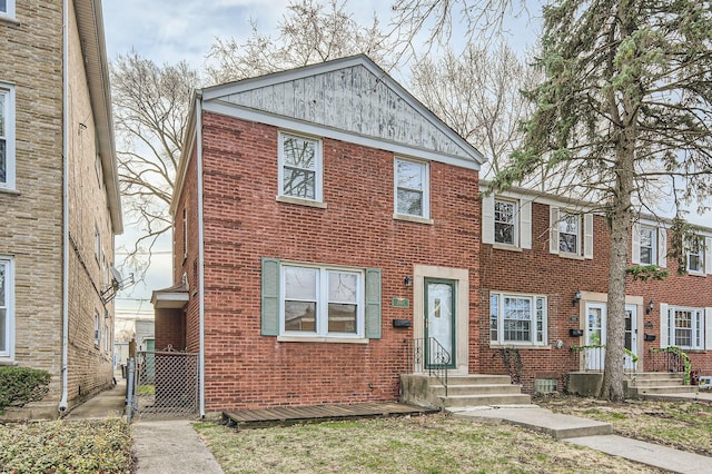 view of property with brick siding and a gate