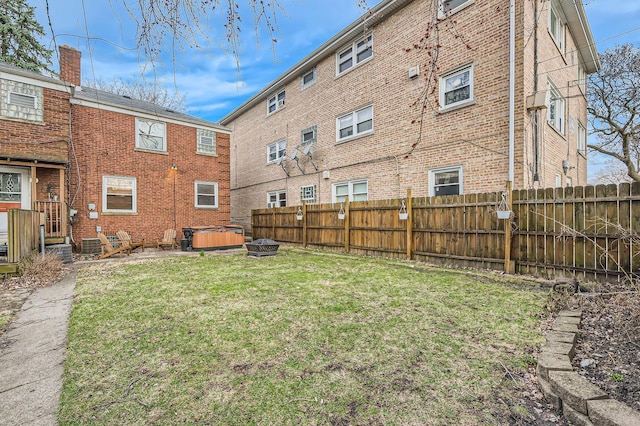 view of yard featuring a hot tub and a fenced backyard