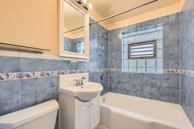 full bathroom featuring plenty of natural light, toilet, vanity, tile walls, and shower / bathing tub combination