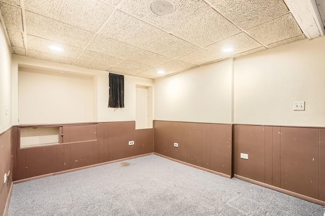 finished basement with recessed lighting, a paneled ceiling, carpet floors, and wainscoting