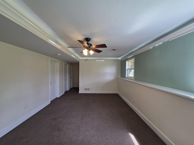 carpeted spare room with visible vents, a ceiling fan, baseboards, and ornamental molding