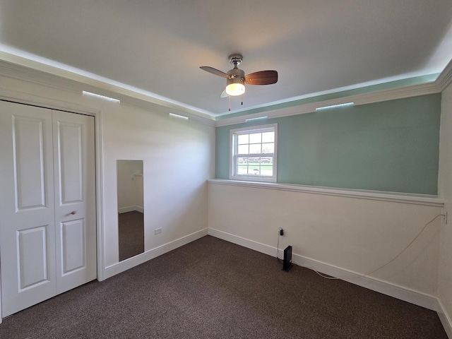 unfurnished bedroom featuring dark colored carpet, baseboards, a closet, and a ceiling fan