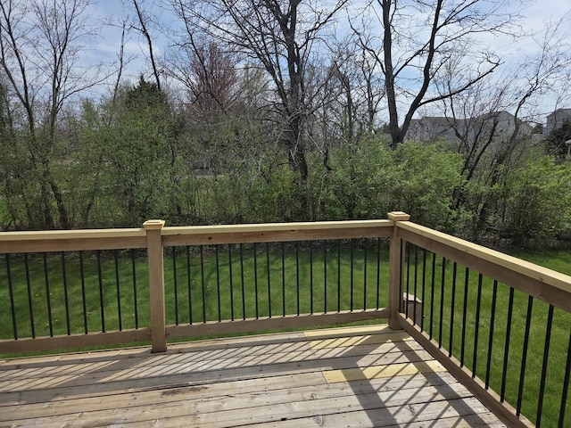 wooden deck featuring a lawn