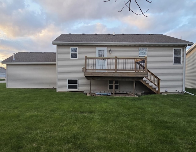 back of house with a wooden deck, roof with shingles, a yard, and stairs