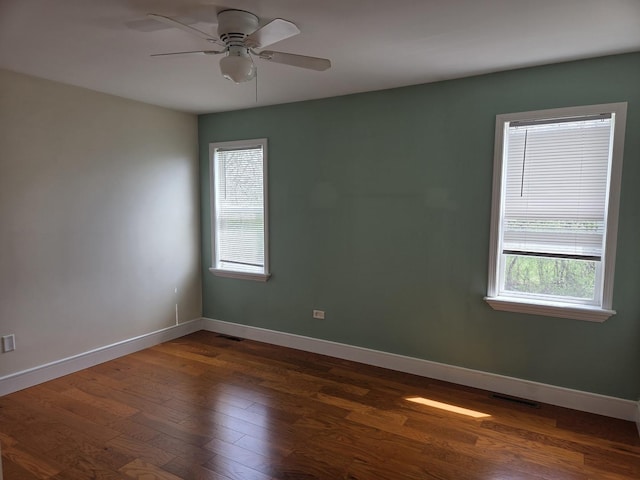 unfurnished room featuring plenty of natural light, visible vents, ceiling fan, and dark wood finished floors
