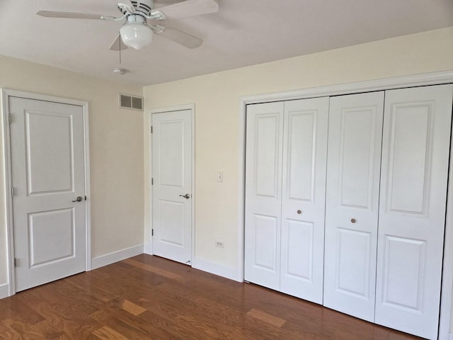 unfurnished bedroom featuring visible vents, a ceiling fan, a closet, baseboards, and dark wood-style flooring