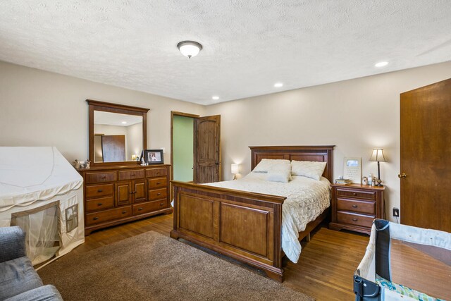 bedroom featuring recessed lighting, a textured ceiling, and dark wood finished floors