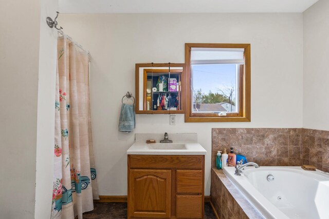 bathroom with a tub with jets, curtained shower, and vanity