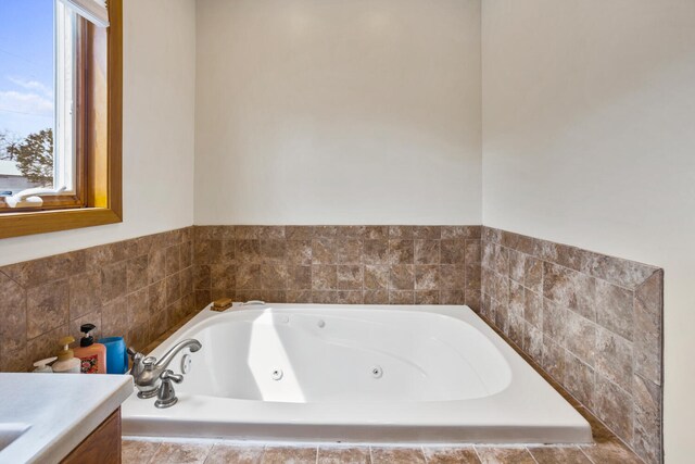 bathroom featuring a tub with jets and vanity