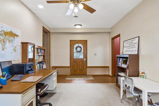 carpeted home office featuring plenty of natural light, ceiling fan, wainscoting, and visible vents