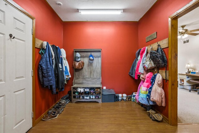 mudroom featuring a textured ceiling, ceiling fan, wood finished floors, and visible vents
