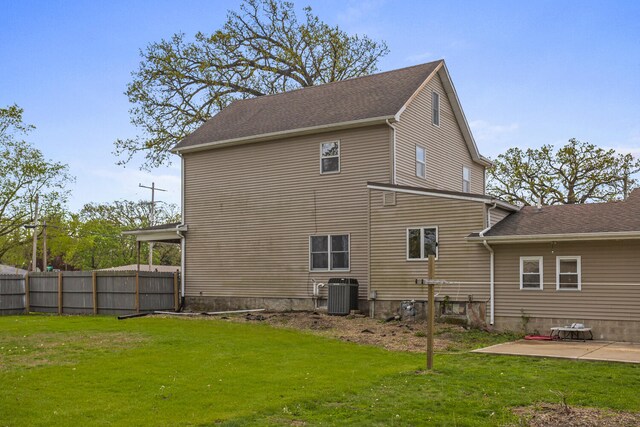 rear view of house featuring fence, a yard, cooling unit, and a patio area