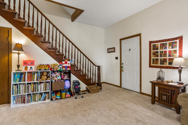 foyer featuring stairway, carpet floors, and baseboards