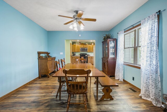 dining space featuring baseboards, ceiling fan, visible vents, and dark wood-type flooring