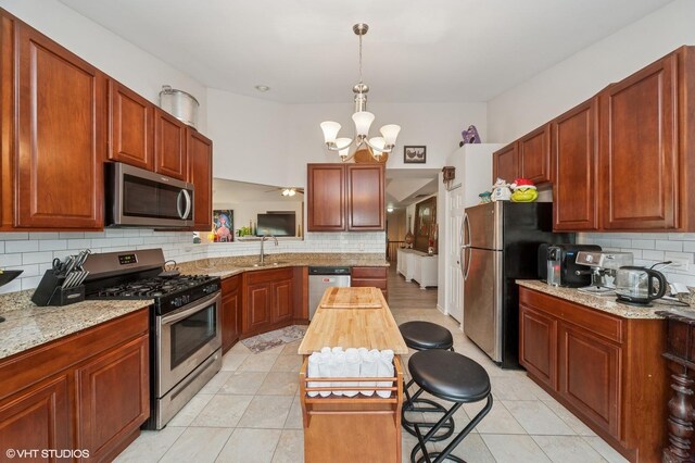 1952 Crenshaw Cir Unit 1952, Vernon Hills, IL 60061 - kitchen featuring appliances with stainless steel finishes, tasteful backsplash, a chandelier, and pendant lighting