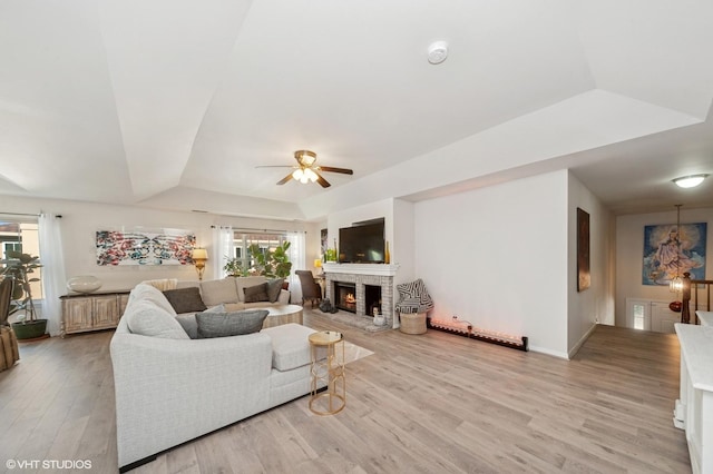 1952 Crenshaw Cir Unit 1952, Vernon Hills, IL 60061 - living area with a ceiling fan, light wood finished floors, a tray ceiling, and a stone fireplace