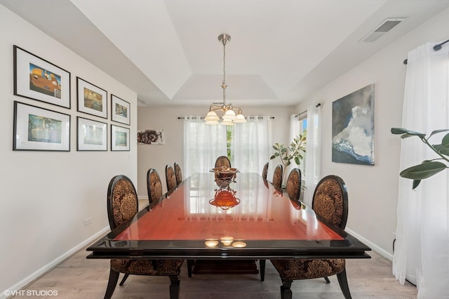 1952 Crenshaw Cir Unit 1952, Vernon Hills, IL 60061 - dining room with a tray ceiling, light wood finished floors, and a chandelier