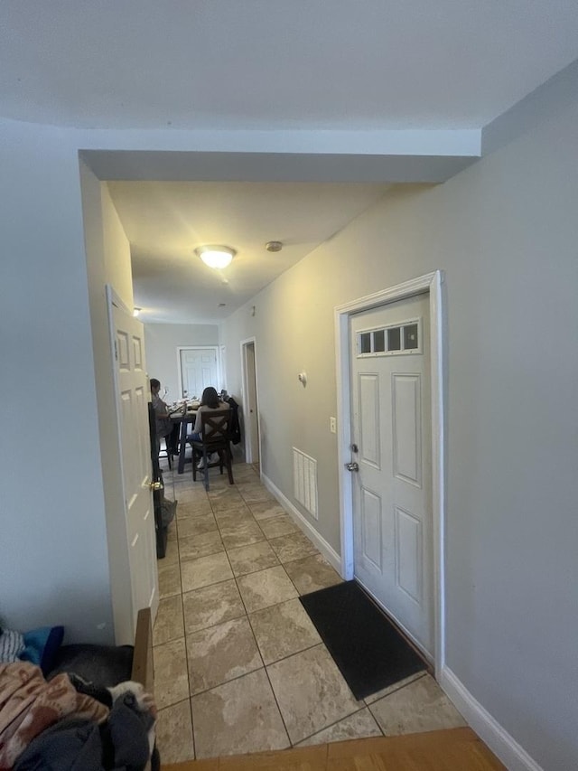 entrance foyer featuring baseboards, visible vents, and light tile patterned floors