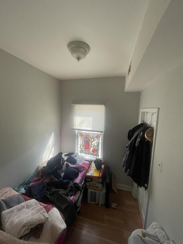 bedroom featuring visible vents and wood finished floors