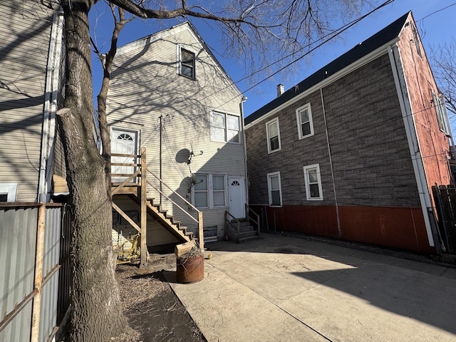 back of house featuring entry steps, a patio, and fence