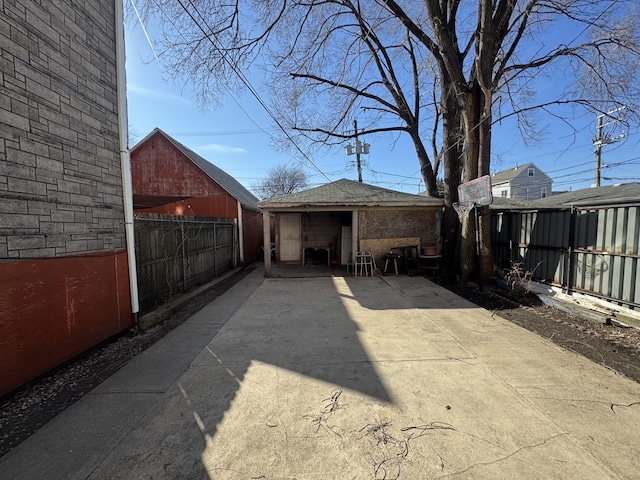 view of patio with an outbuilding and fence