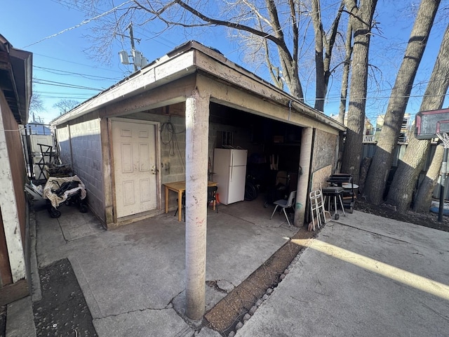 detached garage with fence and freestanding refrigerator