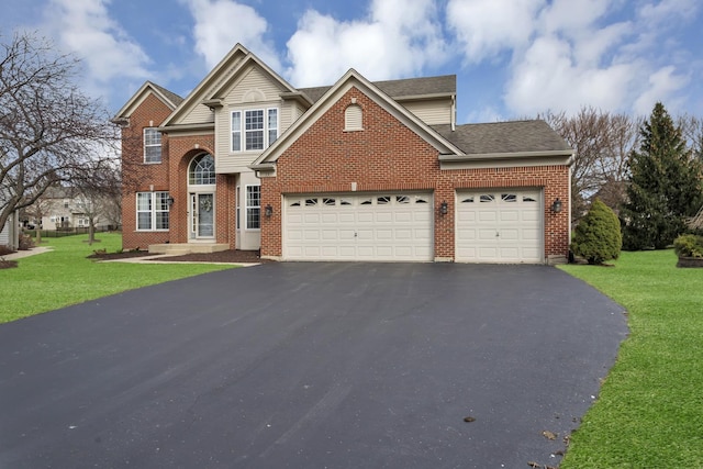traditional home featuring brick siding, aphalt driveway, a front yard, and a garage