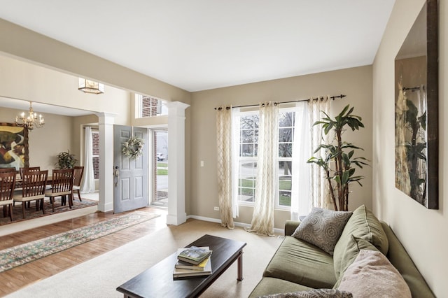 living room with a healthy amount of sunlight, carpet flooring, baseboards, and an inviting chandelier