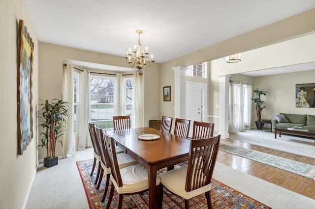 dining space with baseboards, a chandelier, and light wood-type flooring