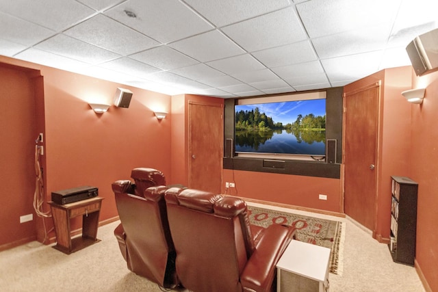 carpeted cinema room featuring baseboards and a paneled ceiling