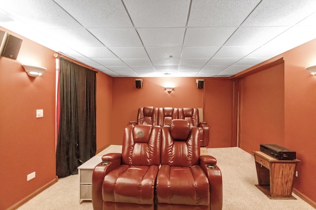 carpeted home theater room with baseboards and a drop ceiling