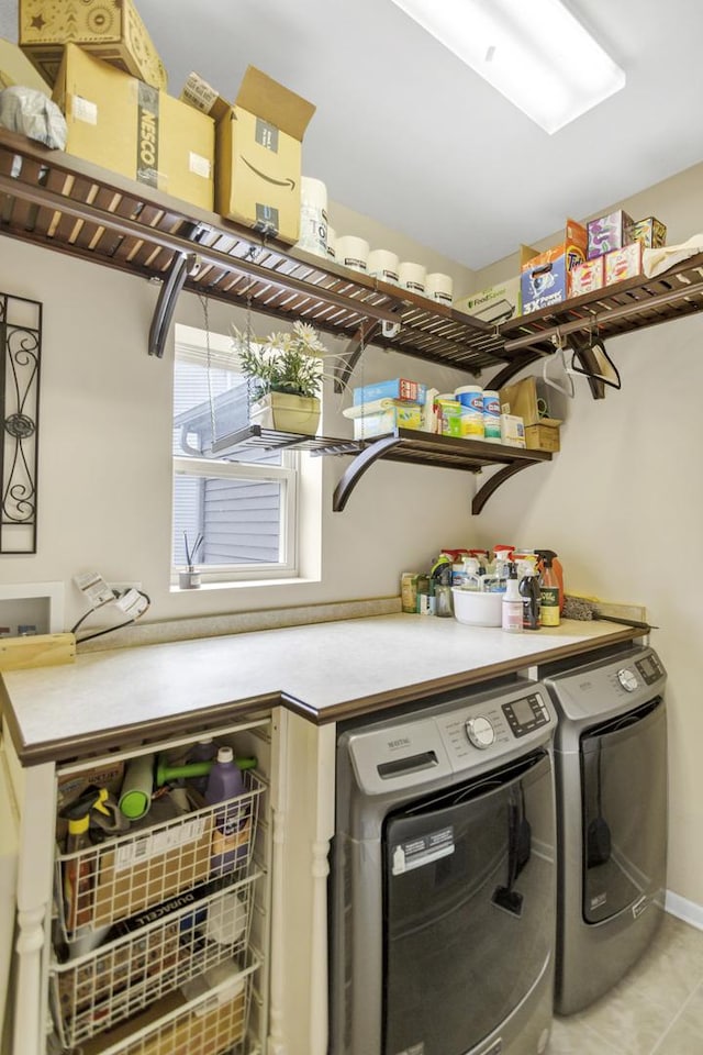 laundry area featuring light tile patterned floors, baseboards, washer and dryer, and laundry area