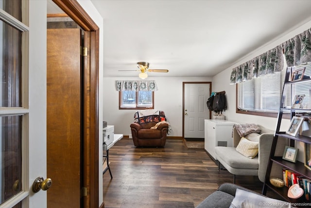 living area with dark wood-style flooring and ceiling fan